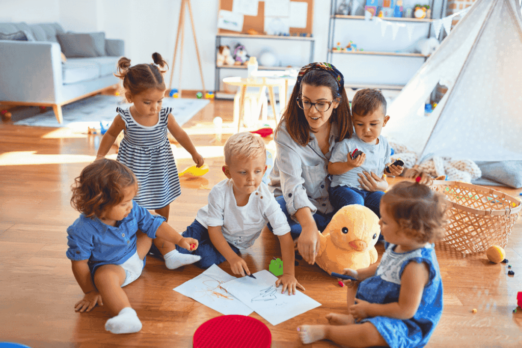 Kita mit spielenden Kleinkindern und einer Erzieherin
