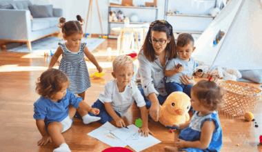 Kita mit spielenden Kleinkindern und einer Erzieherin