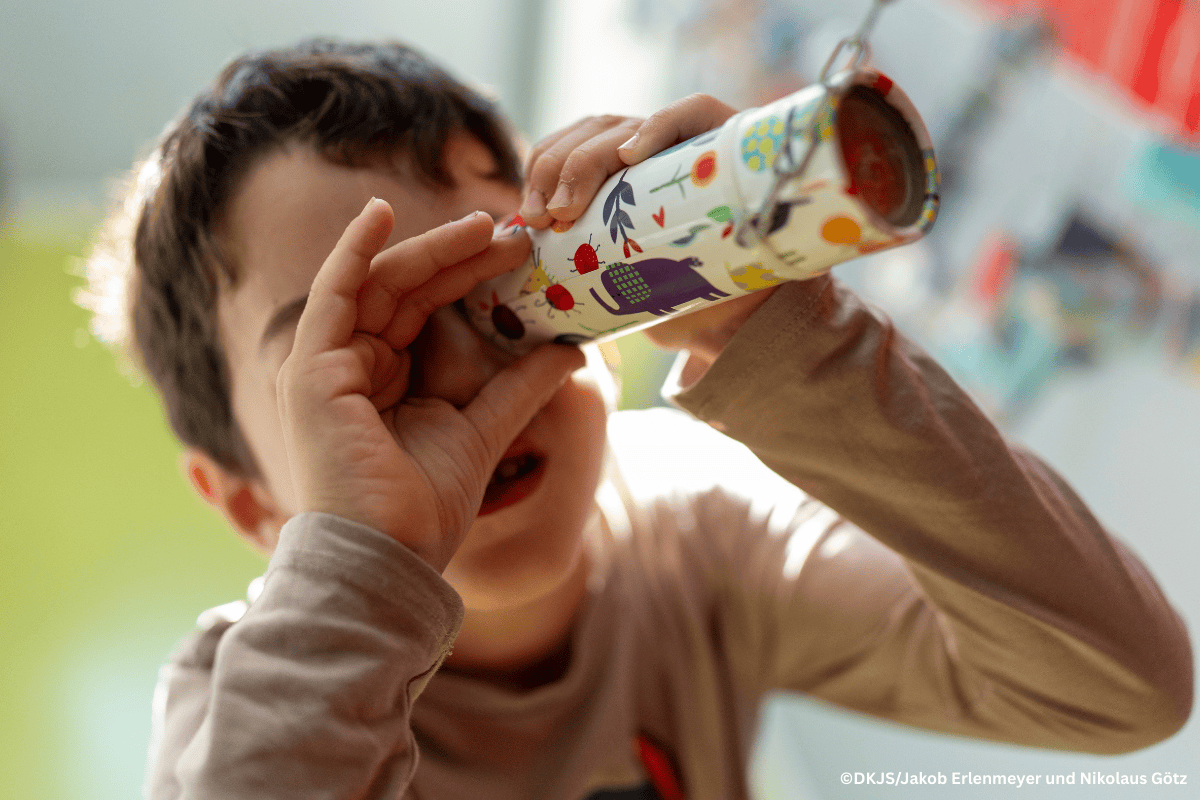 Foto zum Deutschen Kita-Preis: Kind schaut durch Fernrohr